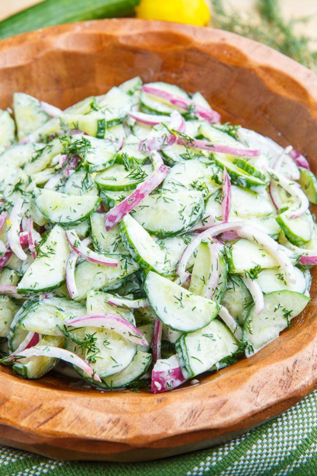 Creamy dilled cucumber salad in a wooden bowl with sliced cucumber, red onion and chopped fresh dill