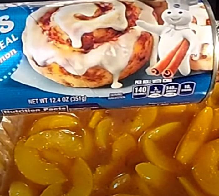 Pillsbury cinnamon rolls on top of peach cobbler with Hennessy