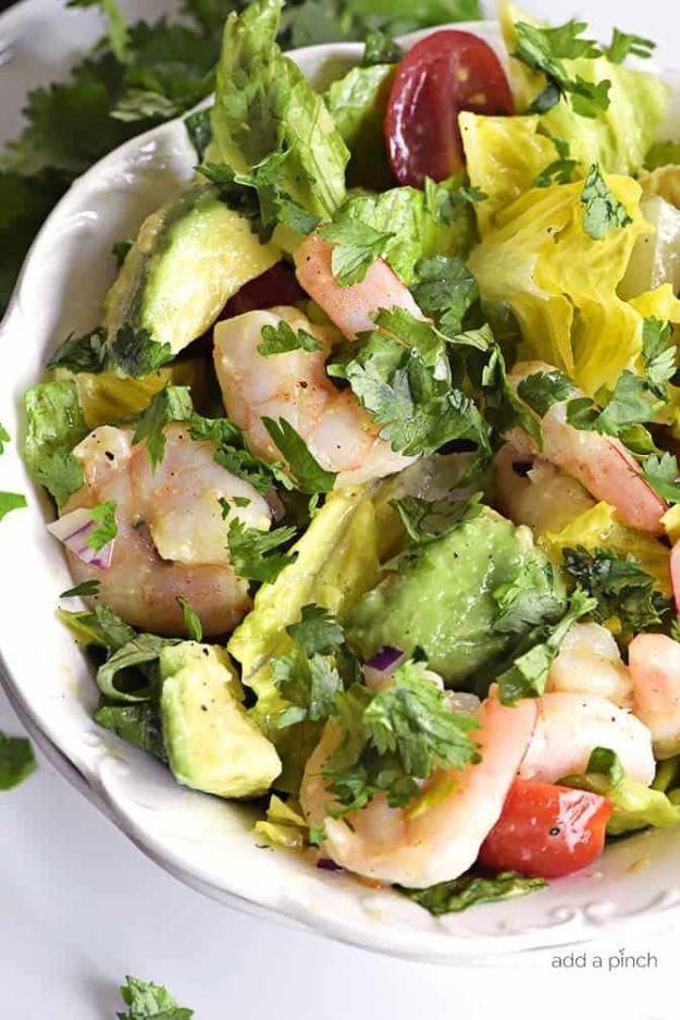 Cilantro lime shrimp avocado salad in a white bowl with shrimp, avocado chunks, tomatoes and cilantro