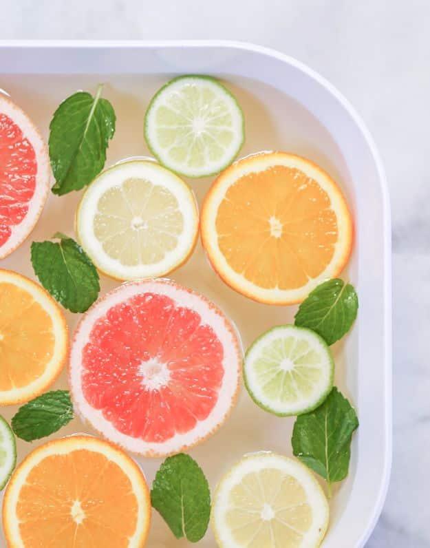 DIY spa night at home, a white tray of water floating grapefruit, orange, lemon and lime slices with fresh mint leaves