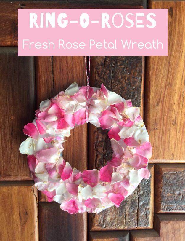 Ring-o-Roses fresh rose petal wreath, a ring of pink and cream fresh petals hung by string on a dark rustic wood wall