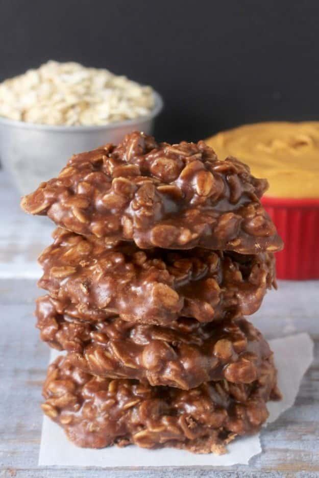 Coconut oil no bake cookies, a tall stack of dark chocolate oat cookies with oats and peanut butter behind