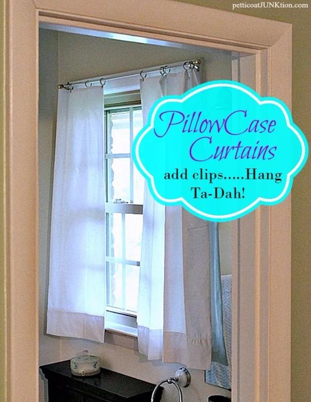 Two white pillowcase curtains clipped to a rod in a small bathroom window, with a typeset PillowCase title
