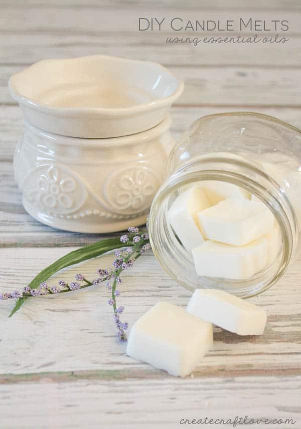 White soy wax melts in a glass jar beside a ceramic wax warmer and a sprig of lavender on a white board