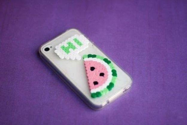 Perler beads phone cover, a clear phone case with a fused watermelon slice and small letter on purple fabric