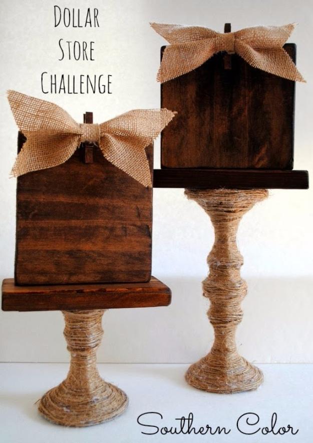 Two photo holders with stained wood tops and twine wrapped glass candlestick bases, trimmed with burlap bows