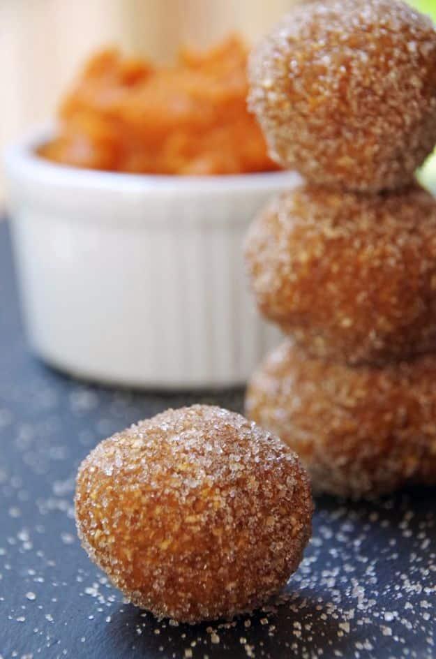 No bake pumpkin balls rolled in cinnamon sugar, stacked on a plate, made with oats and almond butter