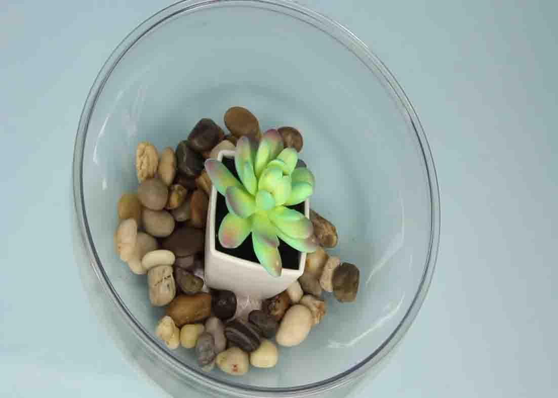 Filling the bowl with stones for the DIY Dollar Tree light-up terrarium