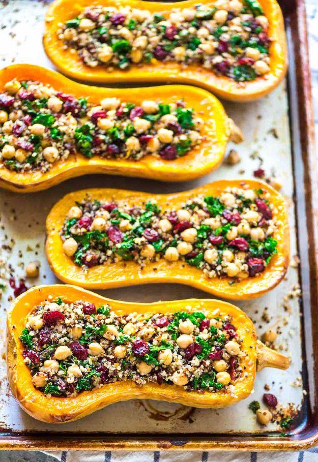 Stuffed butternut squash halves filled with quinoa, kale, chickpeas and dried cranberries on a baking tray