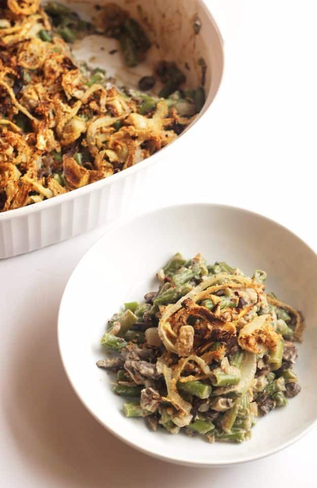 Healthy green bean casserole in a white baking dish and a small bowl topped with homemade crispy fried onions