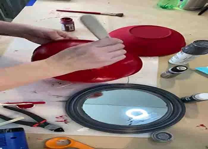 Painting the bowls red for the DIY Christmas bell