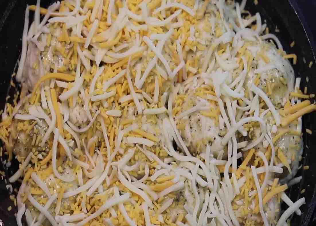 Adding some shredded cheese over the cheesy stuffed biscuit garlic bread