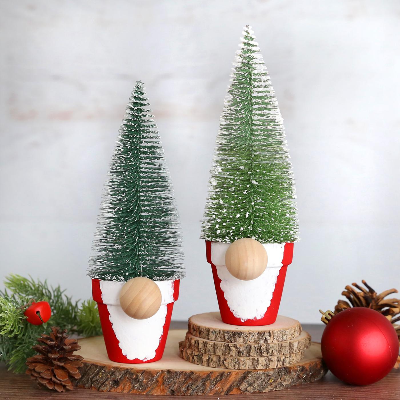 Two gnomes made from small red flower pots with fingerprint beards, wood ball noses and bottle brush tree hats on wood slices