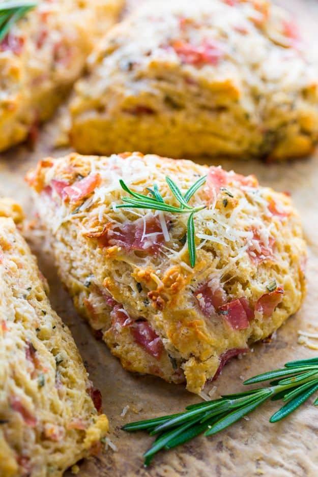 Rosemary parmesan and ham scones on a baking sheet, savory scones flecked with fresh rosemary and ham