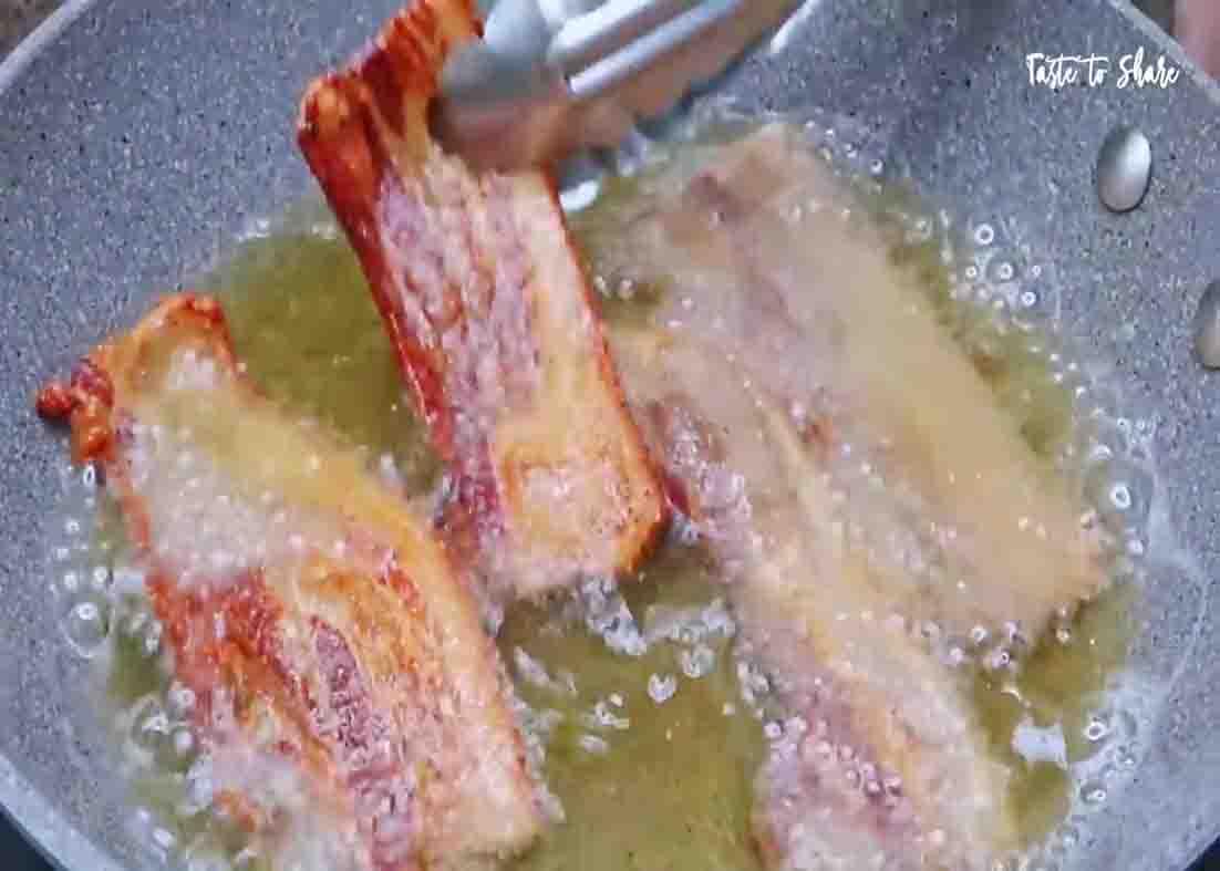Frying the sundried pork bellies until golden brown and crispy