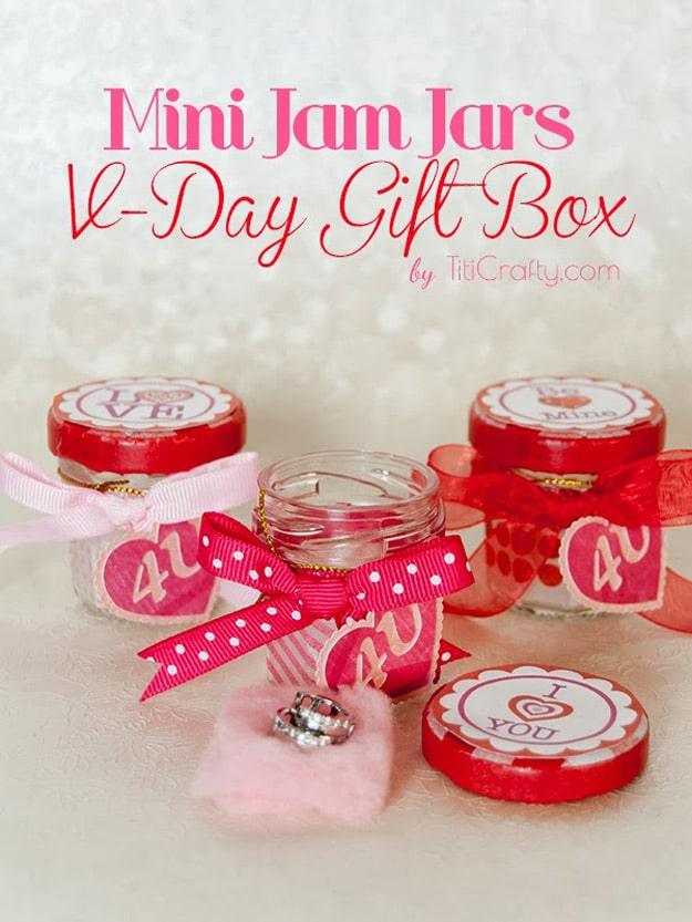 Mini mason jars of red jam labeled and topped with fabric circles as small Valentine's Day gifts to make at home