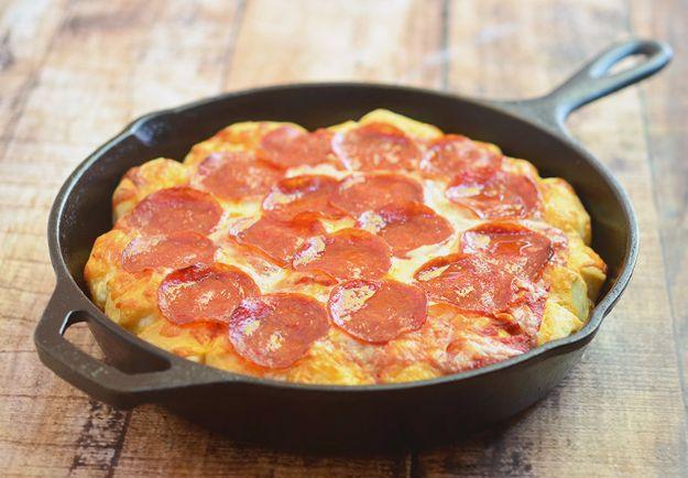 Bubble pizza baked in a cast iron skillet with puffed biscuit dough topped with pepperoni and melted cheese