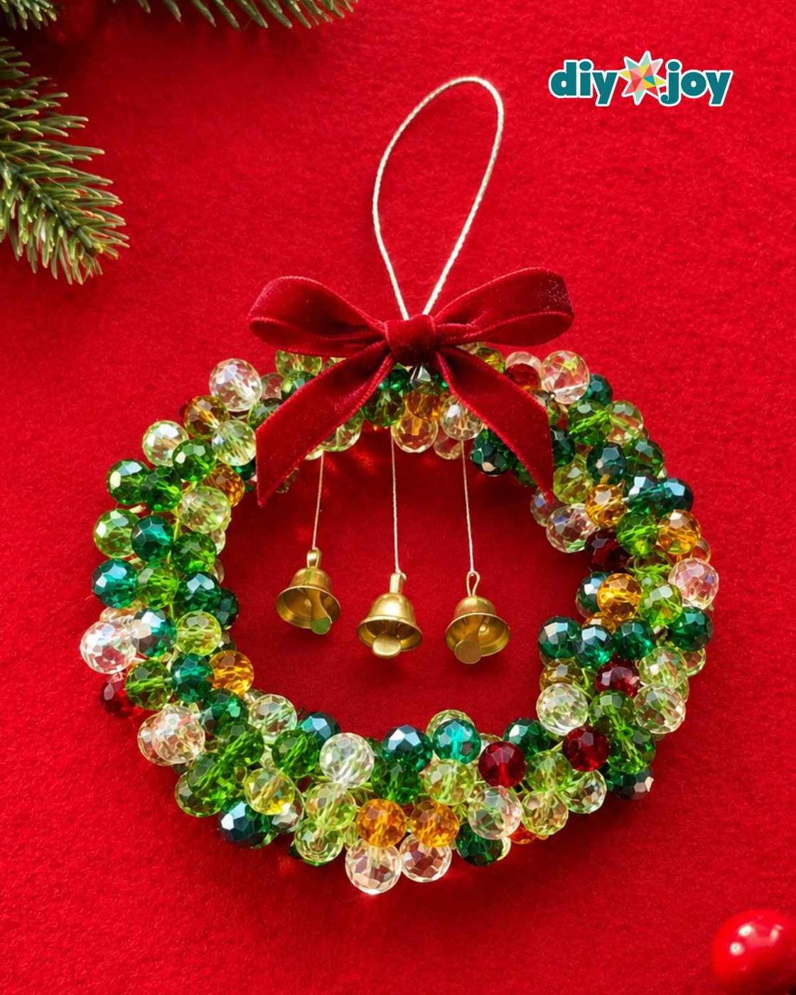 DIY beaded Christmas wreath ornament with a silver hanging loop, velvet bow and three bells on a red background