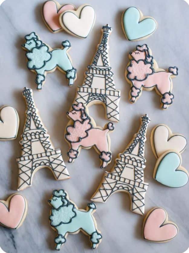 Paris themed cookies iced in muted ivory, pink and turquoise, with Eiffel Tower, heart and poodle shapes