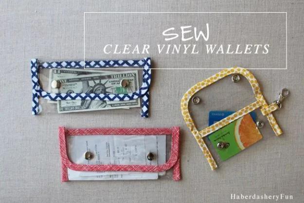 Clear vinyl wallets, three clear vinyl pouches bound in navy, coral and yellow printed tape and closed with snaps