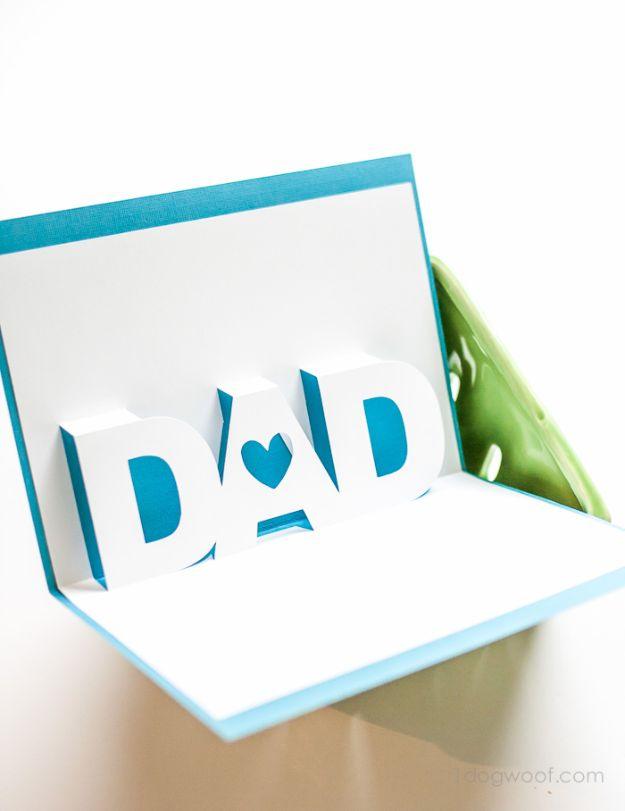 Father's Day pop up card opened flat, white cut letters spelling DAD standing up against bright teal paper