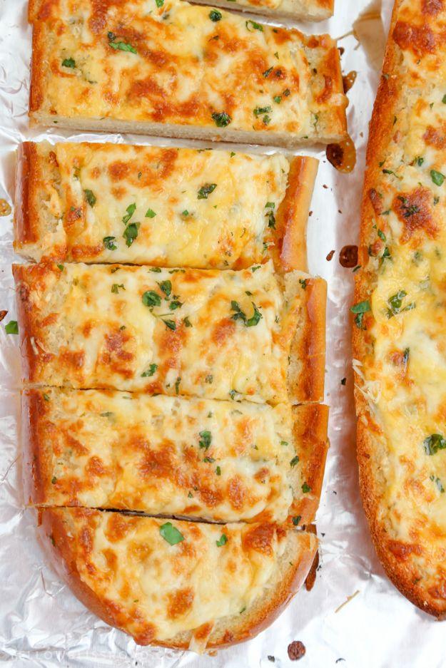 Cheesy garlic bread, a French loaf split lengthwise under browned bubbling cheese and chopped parsley