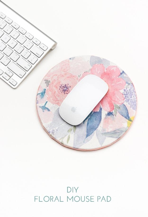 Round cork mouse pad covered in pink and blue watercolor floral fabric next to a white keyboard and mouse
