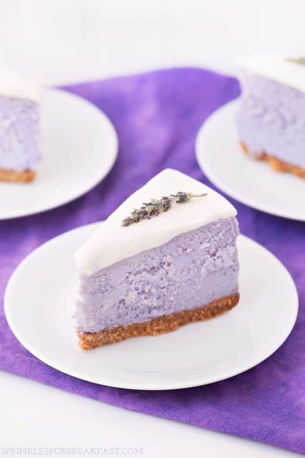 Two white plates on deep purple cloth, each with a pale lavender cheesecake wedge under a thick white topping