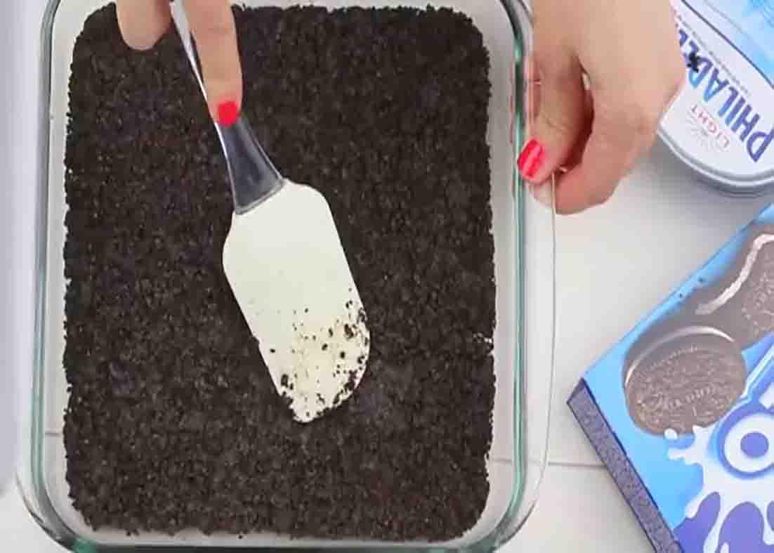 Preparing the crust of the frozen Oreo dessert
