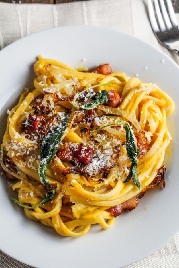 Butternut squash carbonara with fettuccine, pancetta, fried sage leaves and grated cheese on a white plate