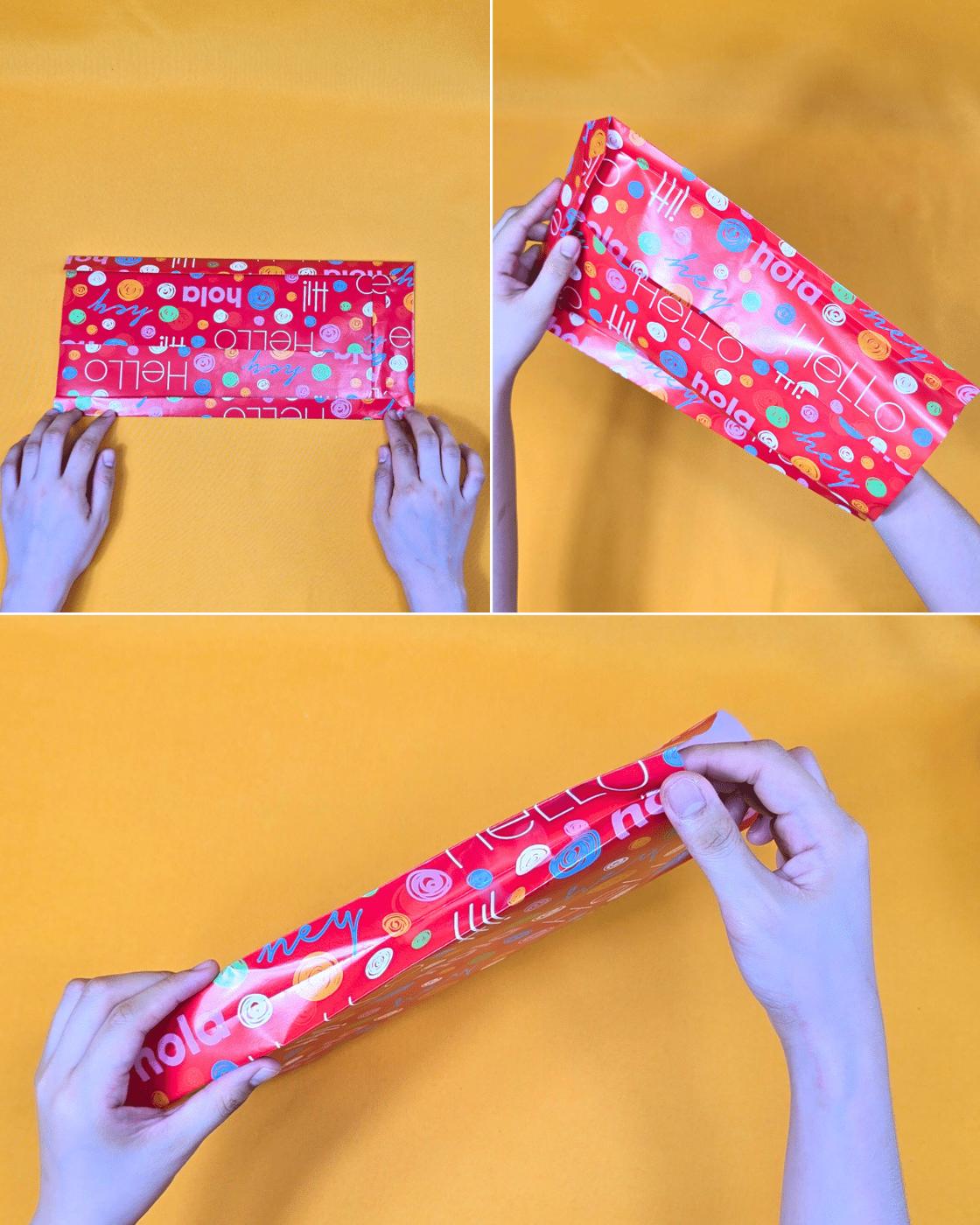 Cheap DIY - hands pressing the side creases inward to shape a red print wrapping paper pouch