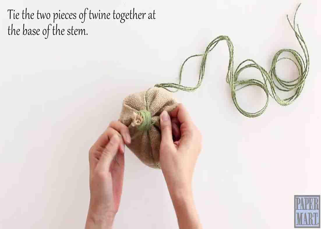 Tying the top of the burlap pumpkin to secure it