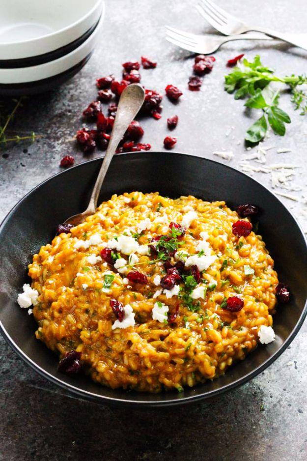 Pumpkin risotto in a shallow bowl topped with crumbled goat cheese, dried cranberries and chopped parsley