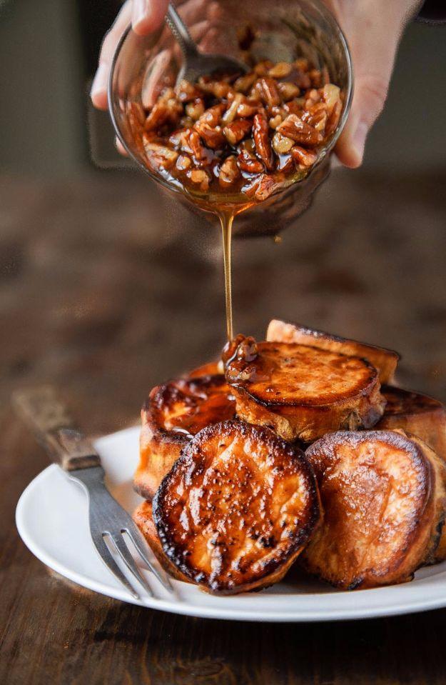 Melting sweet potato rounds on a white plate with maple pecan sauce being poured over from a glass jug by hand