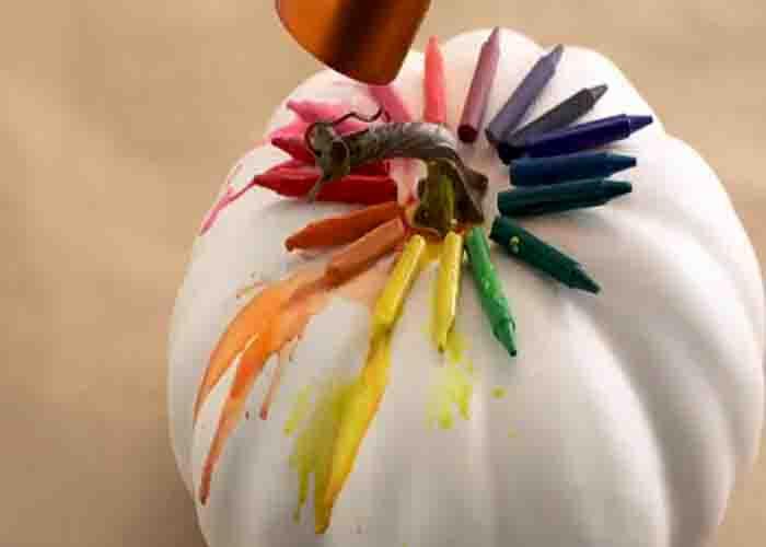Heating the crayons with a hair dryer to melt them down on the pumpkin