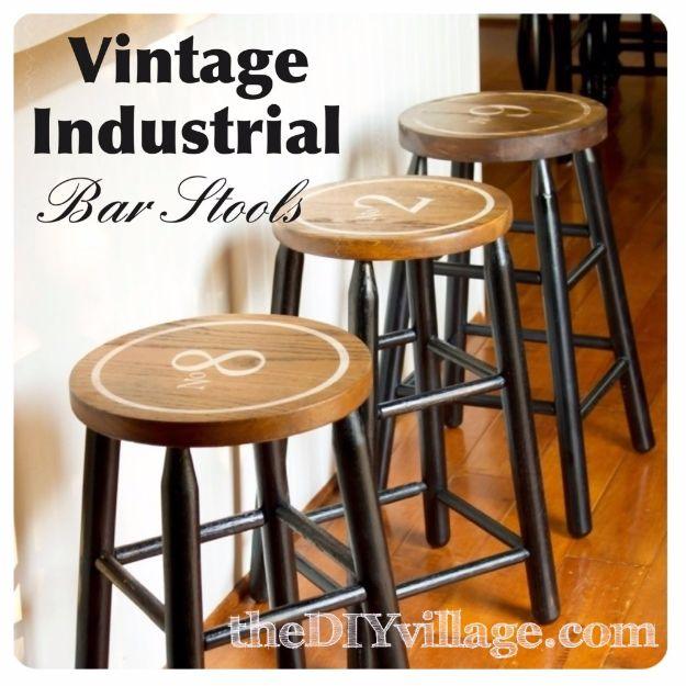 Vintage industrial bar stools with dark metal legs and round stained wood seats, each carrying a large painted numeral