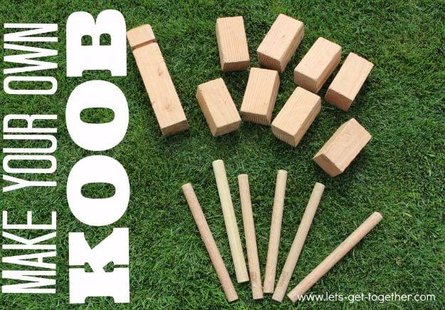 DIY koob lawn game with eight wooden blocks and six throwing dowels laid out on green grass ready to play
