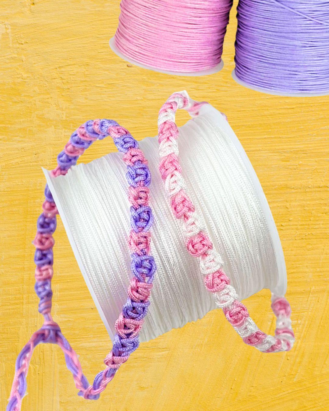 A quick macrame bracelet being knotted on a table, with two colors of cord taped down and the square knots forming