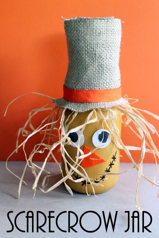 Scarecrow mason jar painted with a face, googly eyes and orange felt nose, topped with a burlap hat and raffia