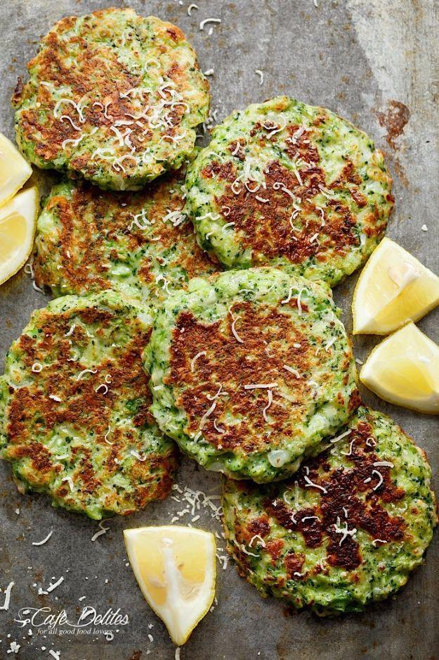 Crispy broccoli parmesan fritters browned on a bare metal baking tray, topped with shaved parmesan and lemon wedges