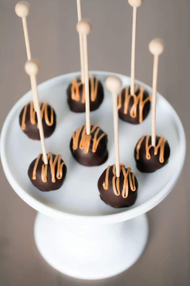 Peanut butter Oreo cookie balls dipped in chocolate and drizzled with peanut butter on sticks, a no bake holiday treat