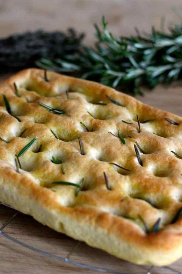 Focaccia di Genova with dimpled golden crust, olive oil pooled in the holes and fresh rosemary on top