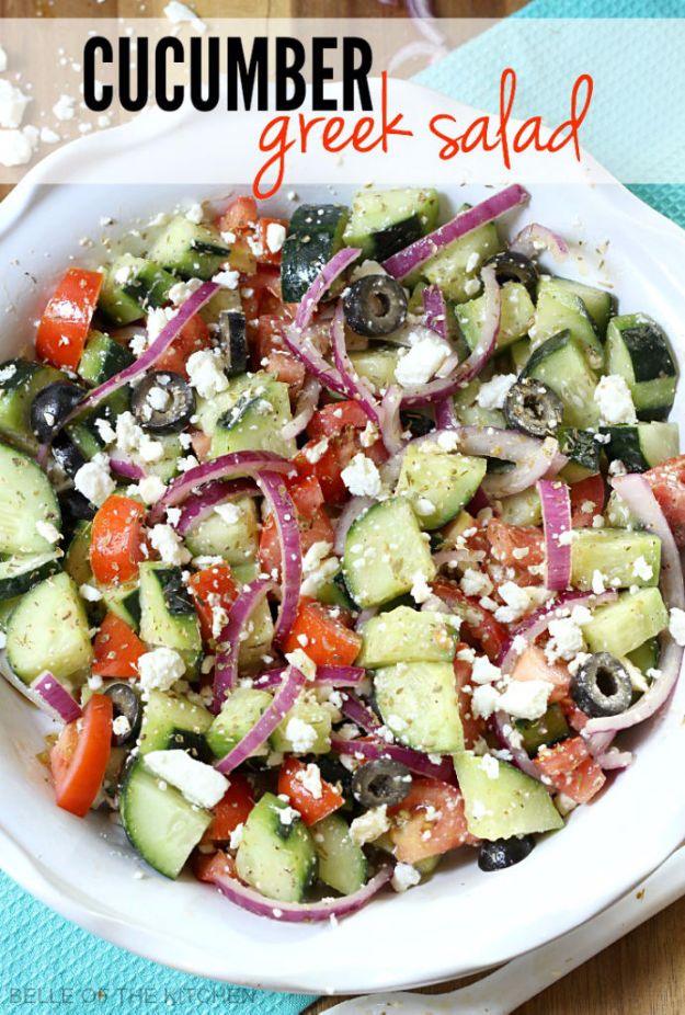 Cucumber greek salad with chopped cucumber, tomato, red onion, black olives and crumbled feta on a white oval platter