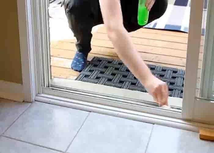 Cleaning the door hinges and sliding door tracks with dish soap