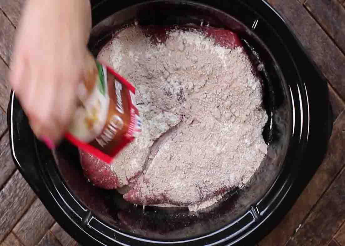 Putting all the ingredients of the Mississippi pot roast on the slow cooker