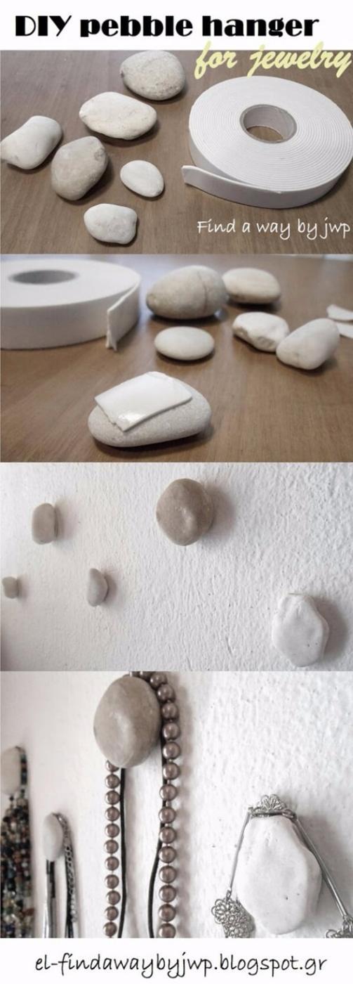 Step panels showing white pebbles with double sided tape pressed onto a wall, hung with necklaces and bracelets