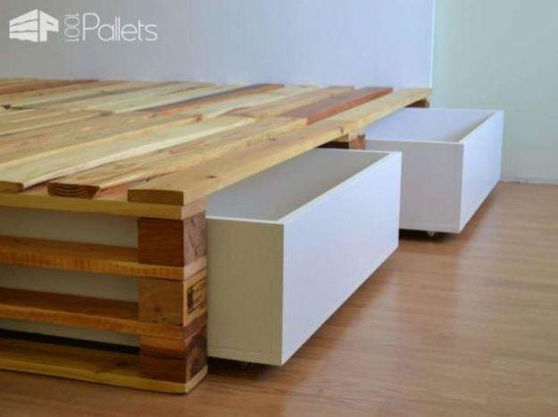 Simple pallet bed platform in mixed tone wood with two white rolling storage boxes underneath on casters