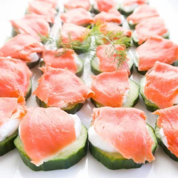 Smoked salmon cucumber bites piped with dill cream cheese on cucumber rounds, an easy gluten free appetizer