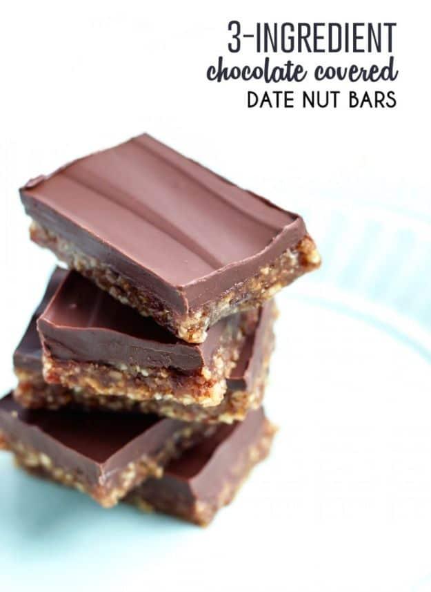 Three ingredient dark chocolate date nut bars stacked to show the nutty date base under a smooth chocolate top