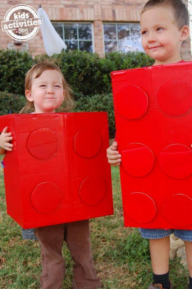 Matching Lego brick costumes made from red spray painted cardboard boxes with round studs glued on the front